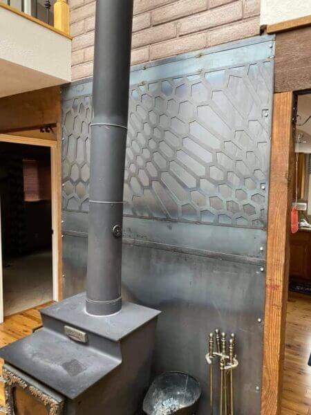 Custom metal design behind a fireplace